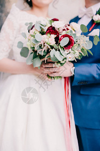 新娘和新郎拿着婚礼花束婚礼花束浓郁的奶油花束wuth图片