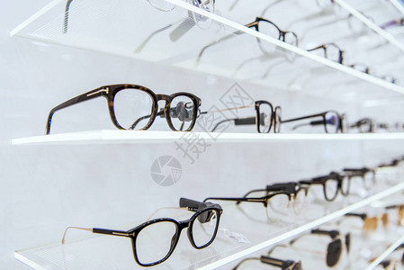 眼科店内带有时装眼镜的白色架背景图片