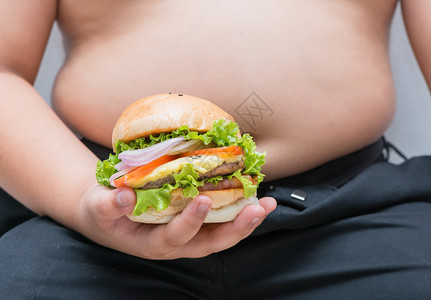 肥胖男孩身上的自制猪肉奶酪汉堡背景图片