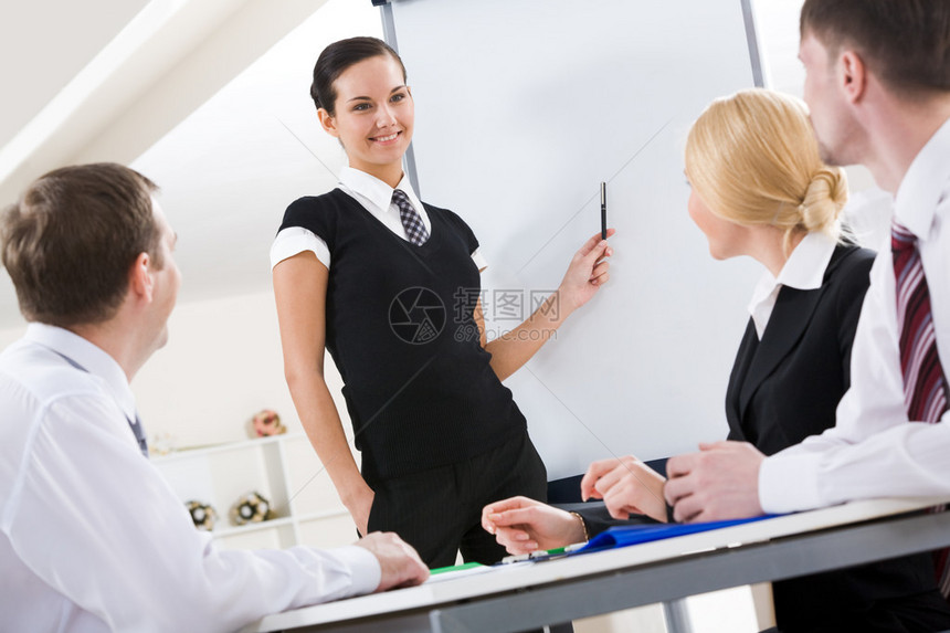 女成功站在白板上向同事解释她的想法的照片图片