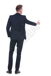 在白色背景上看到一个年轻商人在口袋中握手时按着假想的按钮图片