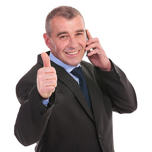 商人在电话时用大拇指举起手势脸上微笑图片