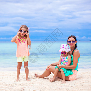 年轻母亲和两个可爱的女儿在阳光明媚的日子里图片