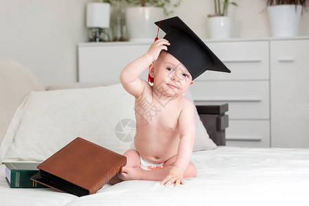 大学毕业帽子中的婴儿天才宝擦额头图片