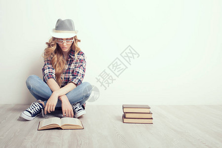 地板上拿着书的女孩图片