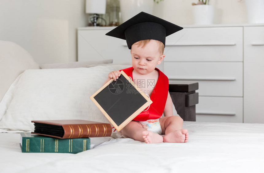 10个月大的孩子戴着毕业帽子和红丝带图片