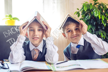 回到学校可爱的孩子们坐在教室的课桌前男孩正在学习课程小学图片