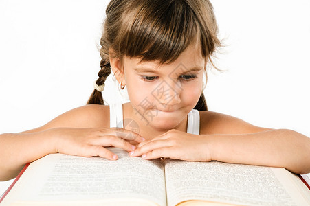 可爱的女孩在一本白色的大书里寻图片