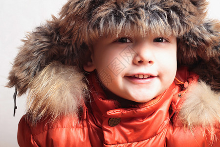 戴着毛皮帽子的微笑孩子的画像时尚小子冬季风格小男孩子们图片