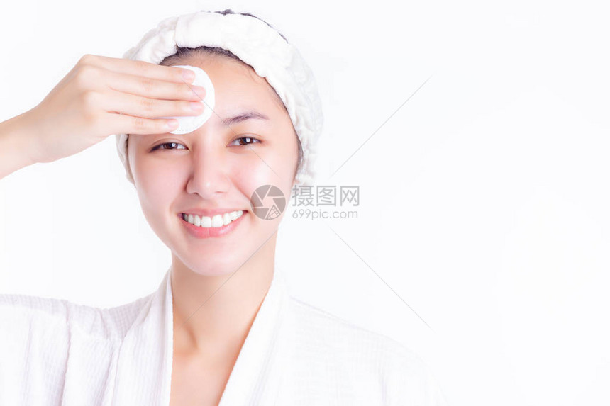 健康的亚洲年轻女用化妆棉卸妆和清洁面部美女沐浴后使用纯棉垫在白色背景上隔离护图片