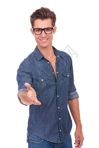 照片中一位随意的青年男子用握手和笑容欢迎你图片