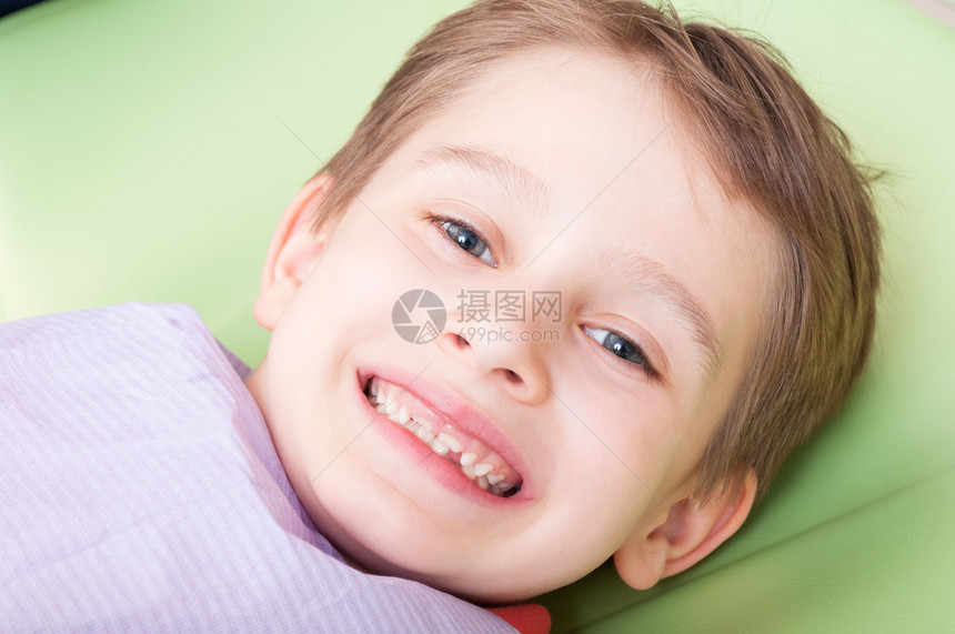 儿童在牙医的椅子或办公室上笑着面脸快图片