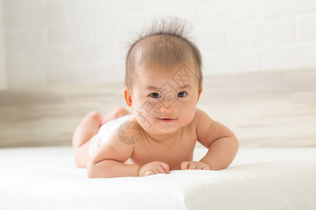 亚洲婴儿在床上爬行的肖像3个月大的图片