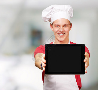 年轻厨师在室内展示数码平图片