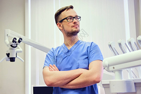 男牙医在一个有背景医疗设备图片