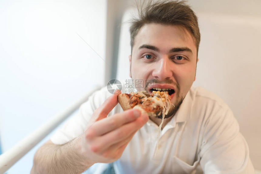 男人吃美味的比萨饼图片