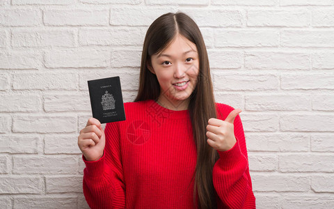 持有加拿大护照的青年女子身穿砖墙图片