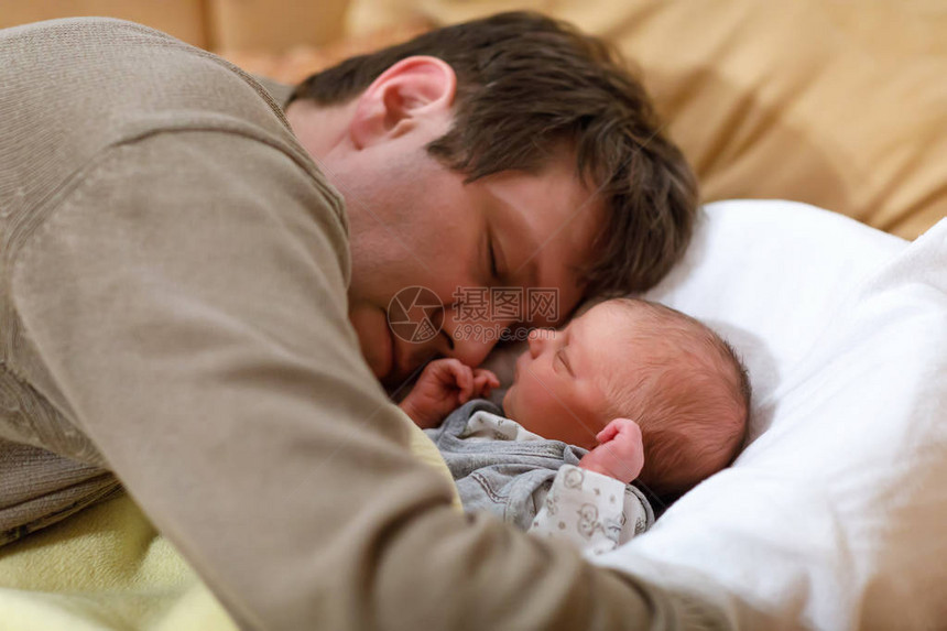中年父亲吻他刚出生的小女儿年轻的爸在家里拥抱和拥抱女婴快乐的父母图片