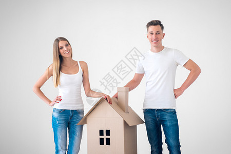 有纸板房子的愉快的夫妇背景图片