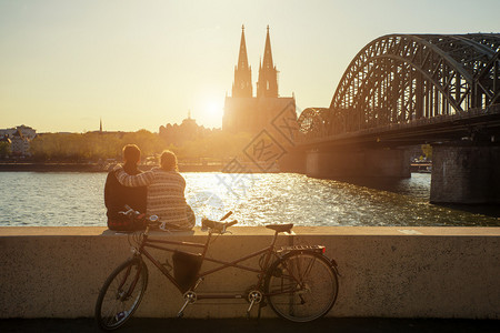 年轻浪漫情侣在德国科隆度假在科隆大教堂附近坐着的图片