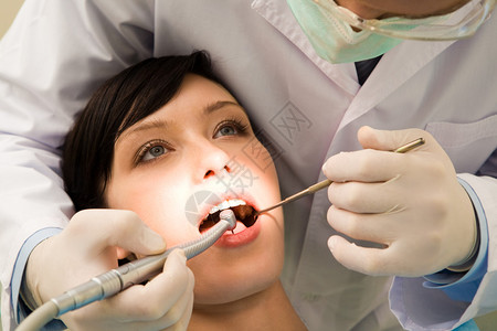 年轻女在牙科医生检查时张开嘴图片