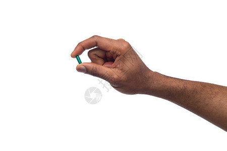 男黑人在大拇指与白种背景隔离的食腐动物之间握有避孕药图片