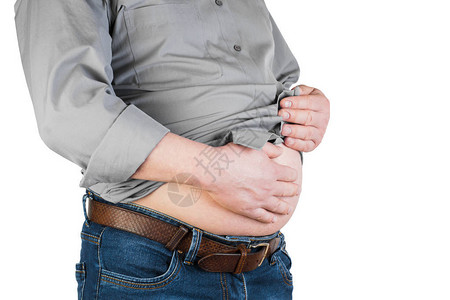 一个人用双手触摸胃部脂肪的体重过是肥胖的概念图片