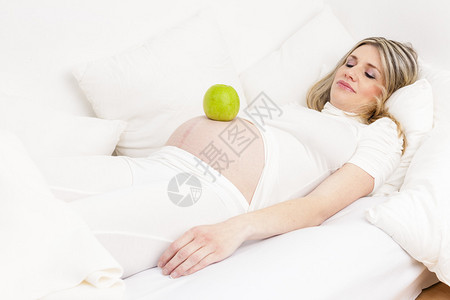 孕妇睡在床上吃着青苹果图片