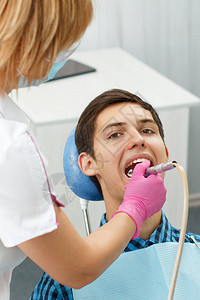 女牙医在牙科办公室治疗病人牙齿图片