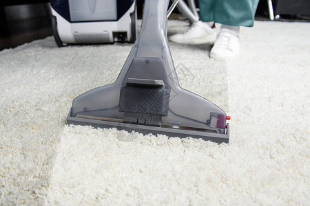 与专业吸尘清洁工一起清洗白地毯的图片