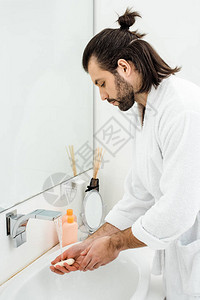 在浴袍洗手间洗手的图片
