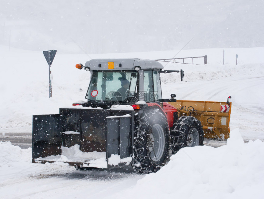 扫雪机拖拉机在冬季清扫道路图片