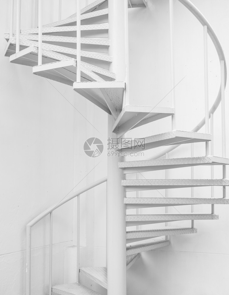 本底白钢螺旋楼梯和白墙图片