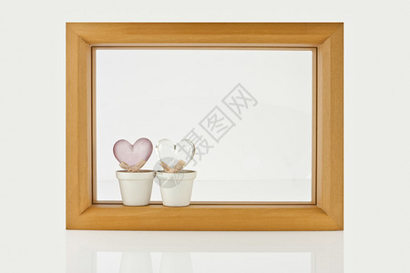 木框架和两颗心在白色背景与反射背景图片