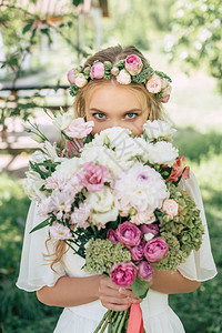 金发美女新娘拿着花束看着图片