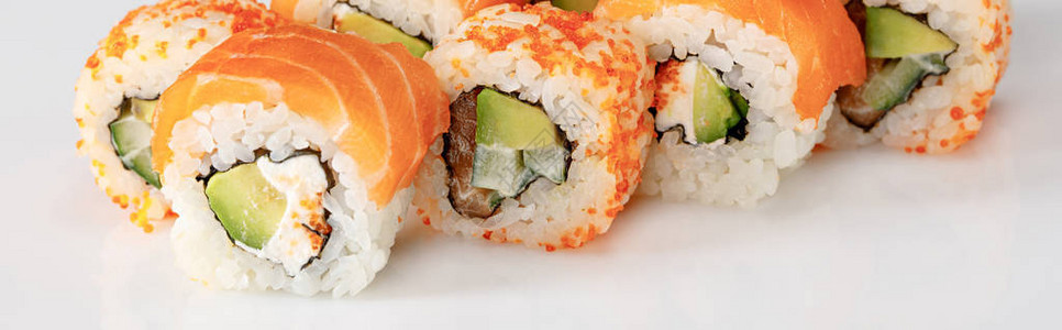 美味的费城和加州寿司与鲑鱼和马萨戈鱼子酱在白色背景图片