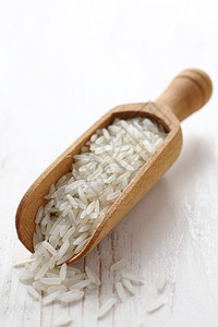 白色背景上抛光长米粒的木勺高清图片