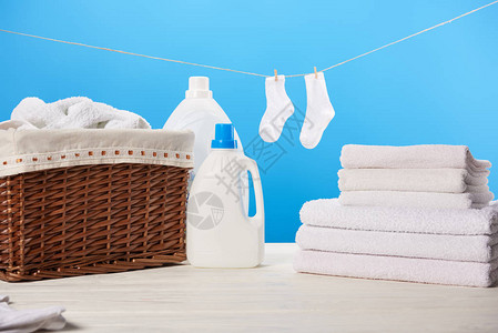 洗衣篮装有洗衣液的塑料容器一堆干净软毛巾和挂在蓝色绳图片
