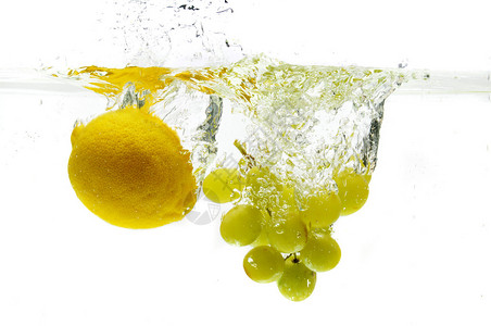柠檬和葡萄掉入水中与白色背景隔离图片
