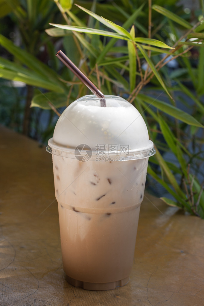 冰咖啡拿铁咖啡和奶油在塑料杯里图片