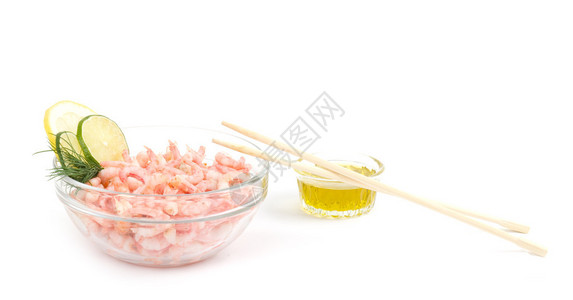 盘子上的美味煮虾和白色背景上的筷子图片