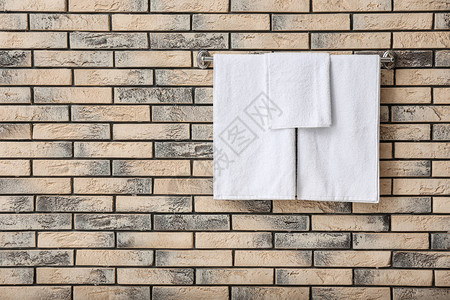 砖墙上有白色毛巾的架子图片