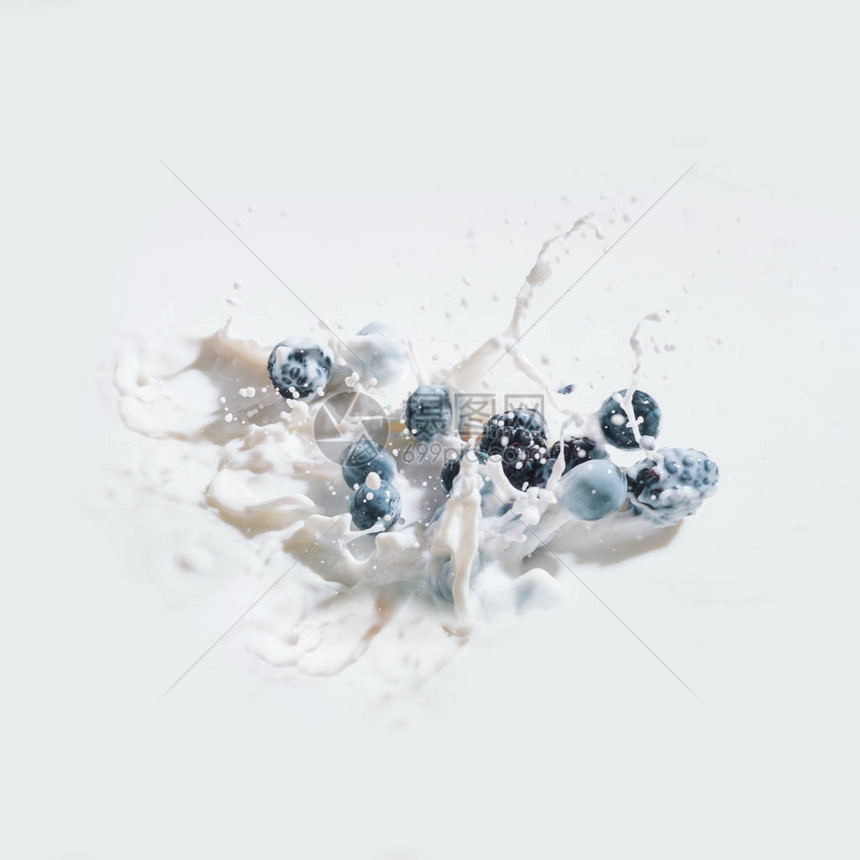 浆果落入牛奶中白色背景上有滴图片