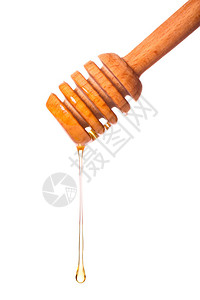 蜂蜜从白色背景上孤立的木勺上滴下来图片