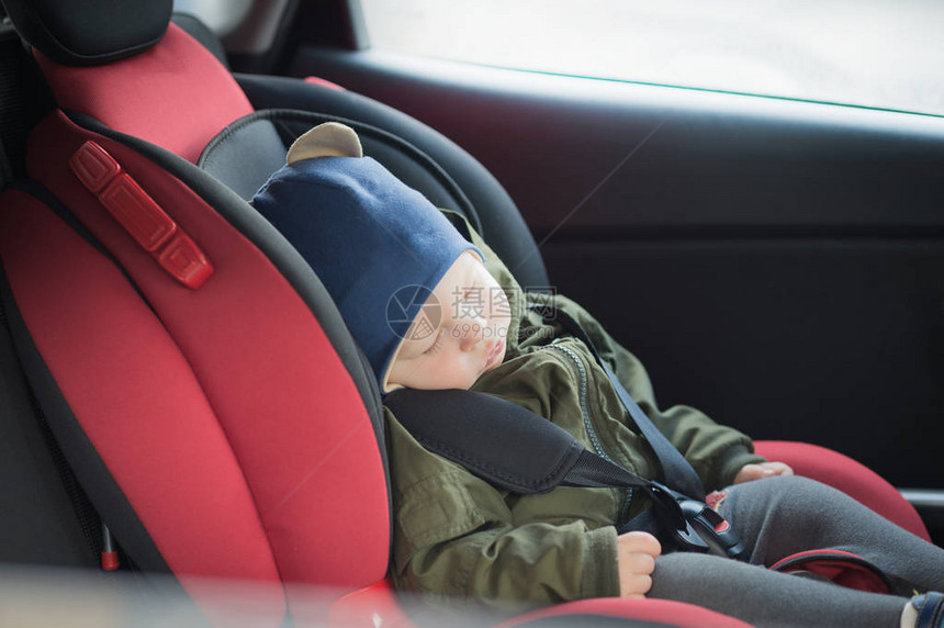 关闭了睡在现代汽车座椅上的白种人可爱男婴儿童在路上行驶的在带小孩的车辆中地旅行系好带着蹒跚学图片