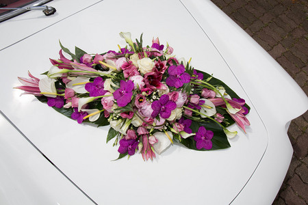 老式白色婚车装饰着紫色的花朵图片