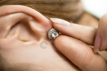 女人戴上钻石耳环的特写照片图片