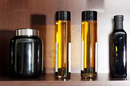 含透明玻璃橄榄油容器和香料及调味品的木制厨房架子图片