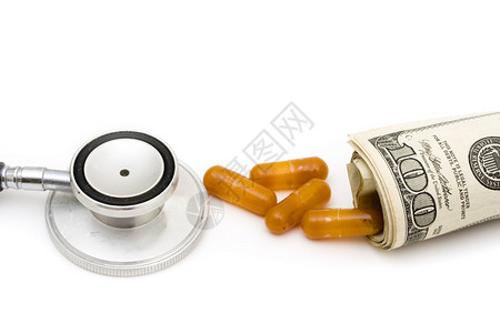 一个听诊器和药片加上100美元的账单白种背景被孤立图片