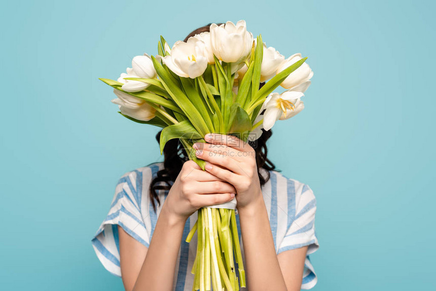 青春女子用蓝色孤立的白色郁金香花图片